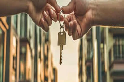 Symbolische Schlüsselübergabe vor modernen Wohngebäuden – Hausverwaltungswechsel im Allgäu