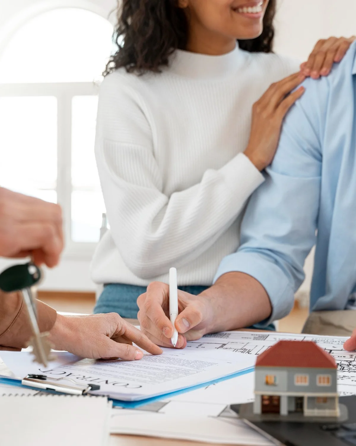 Glückliches Paar unterschreibt Kaufvertrag für neues Haus – Immobilienverkauf mit RGI Immobilien in Pfronten und Füssen